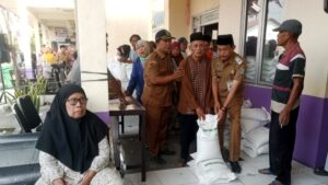 Kepala Desa Dan Warga KPM saat menerima Bantuan Pangan 3 Karung beras @ 10 Kg
